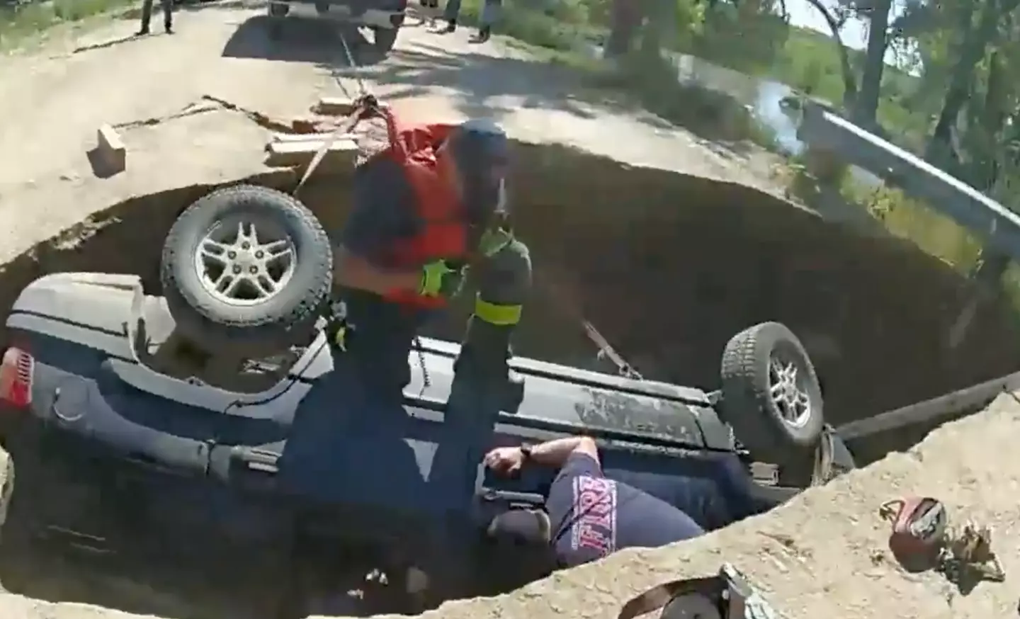 The car was stuck upside down in a sinkhole.