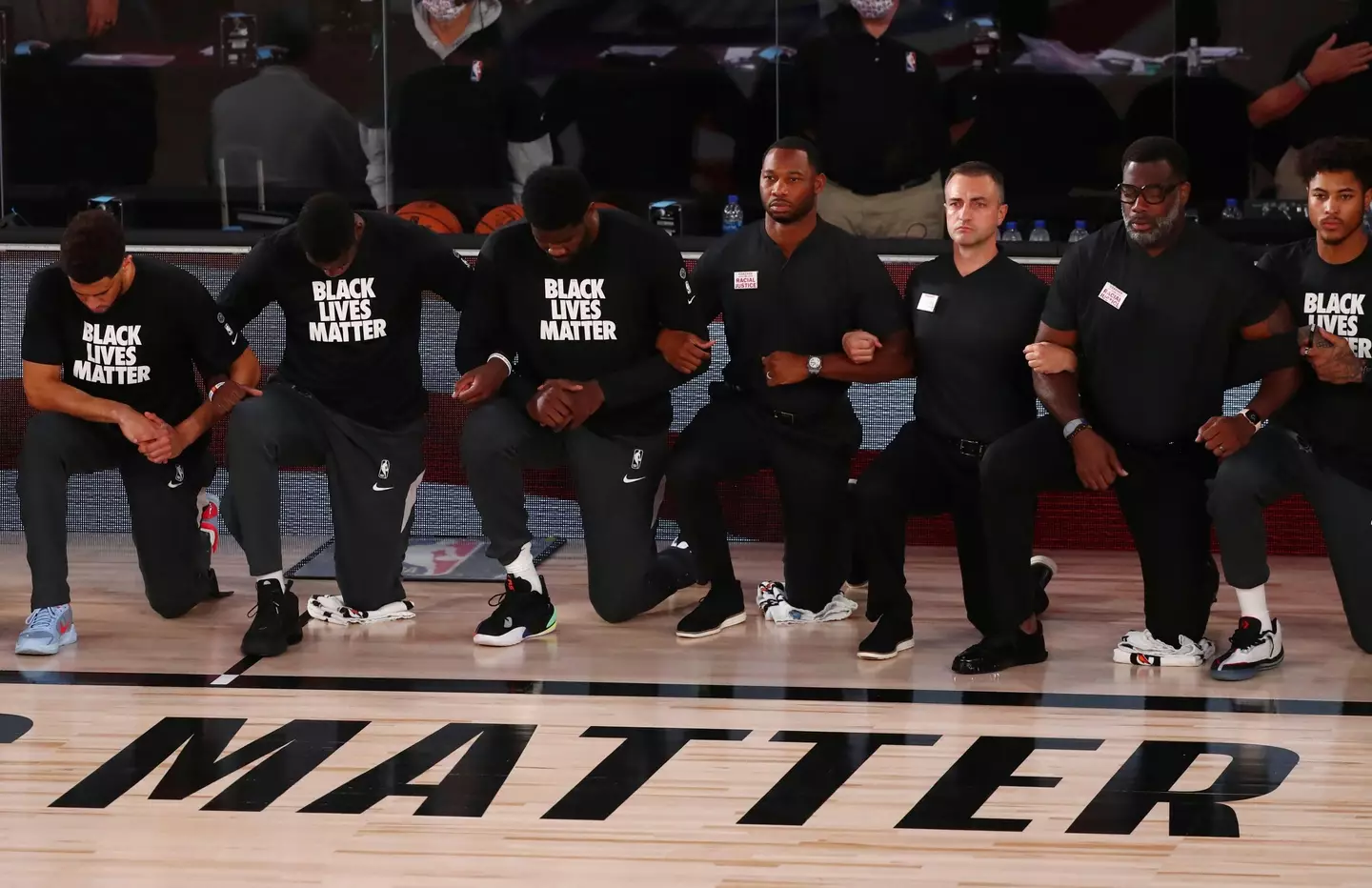 Phoenix Suns players kneel behind a Black Lives Matter logo on 31 July 2020.