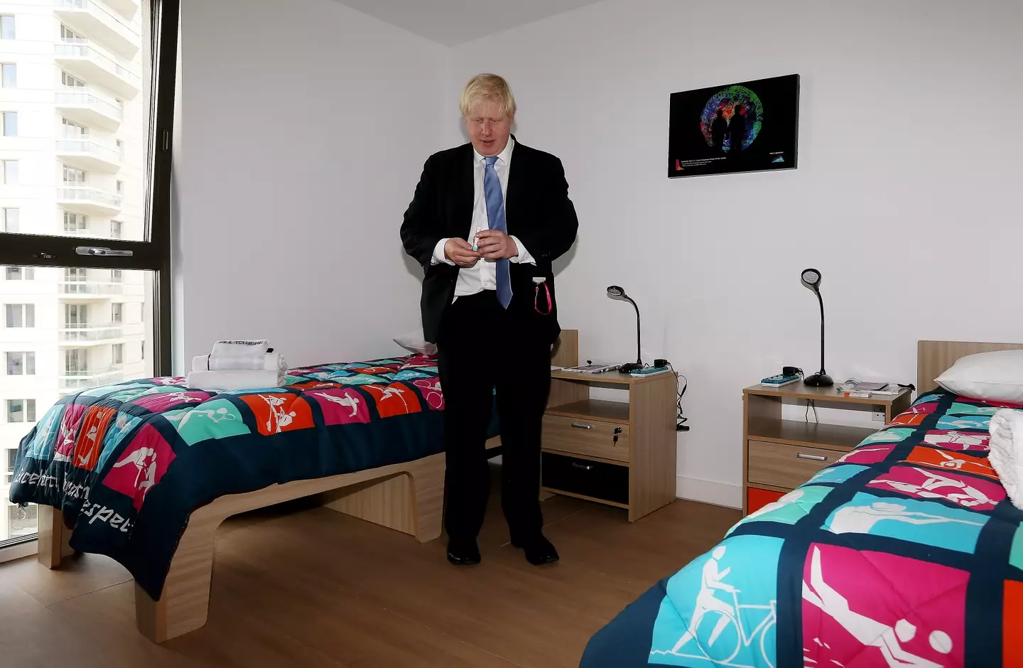Boris Johnson observes the rooms at the Olympic village. Image: Getty