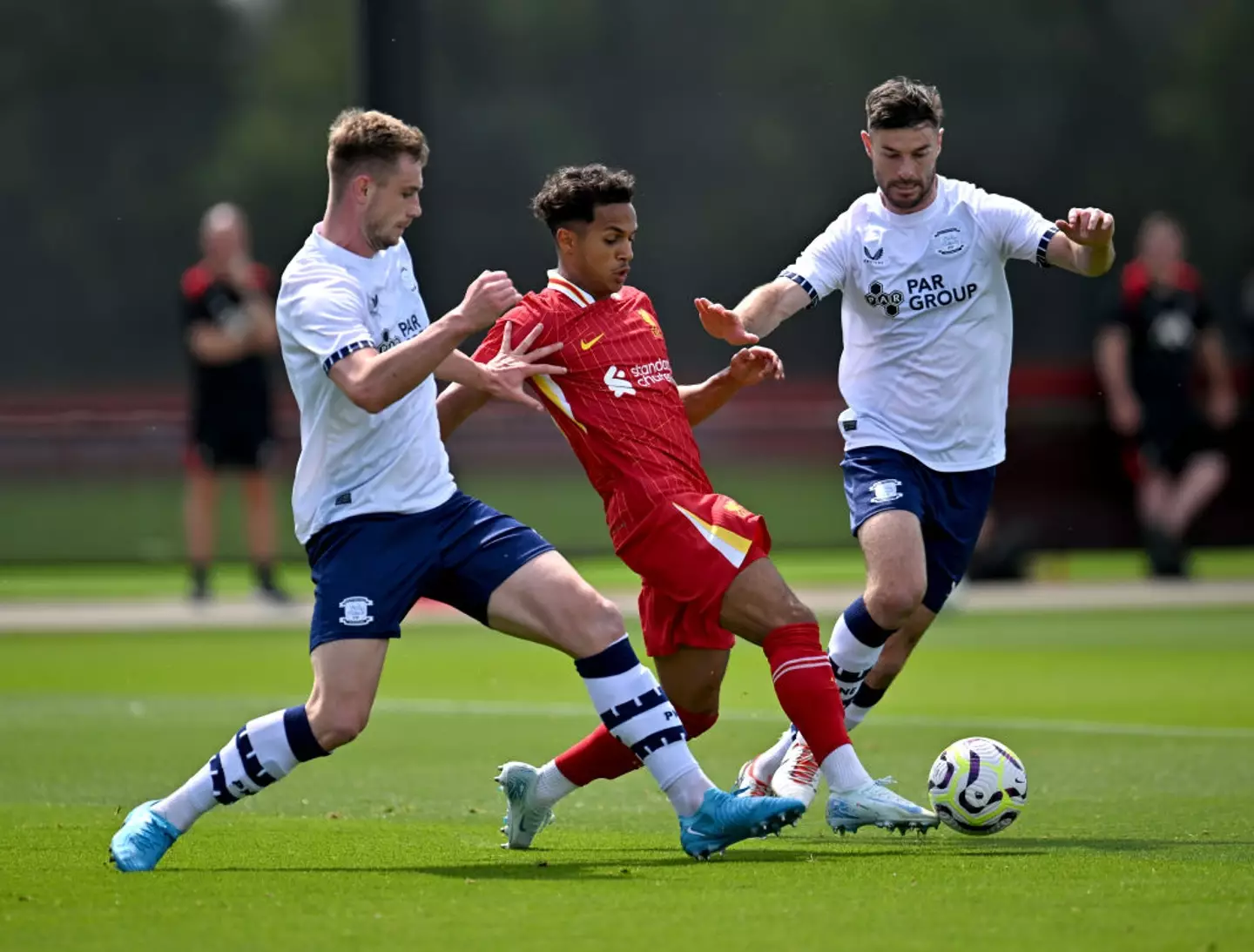 Liverpool's Fabio Carvalho battles for the ball against PNE's Liam Lindsay and Andrew Hughes -