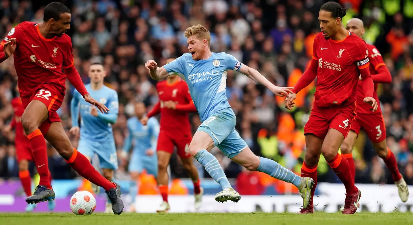 Kevin De Bruyne runs away from Virgil Van Dijk. PA Images / Alamy