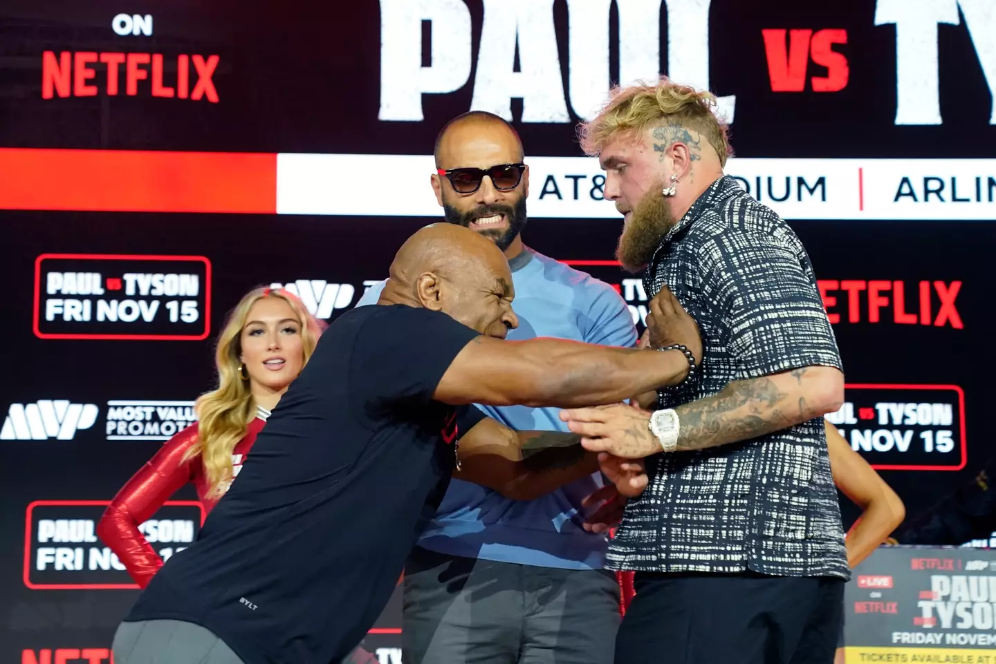 Mike Tyson pushes Jake Paul during a staredown. Image: Getty
