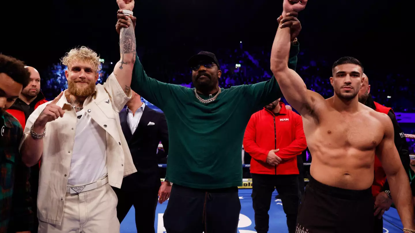 Jake Paul (left) and Tommy Fury (right) have their arms raised by Dereck Chisora during a boxing event in 2022 (