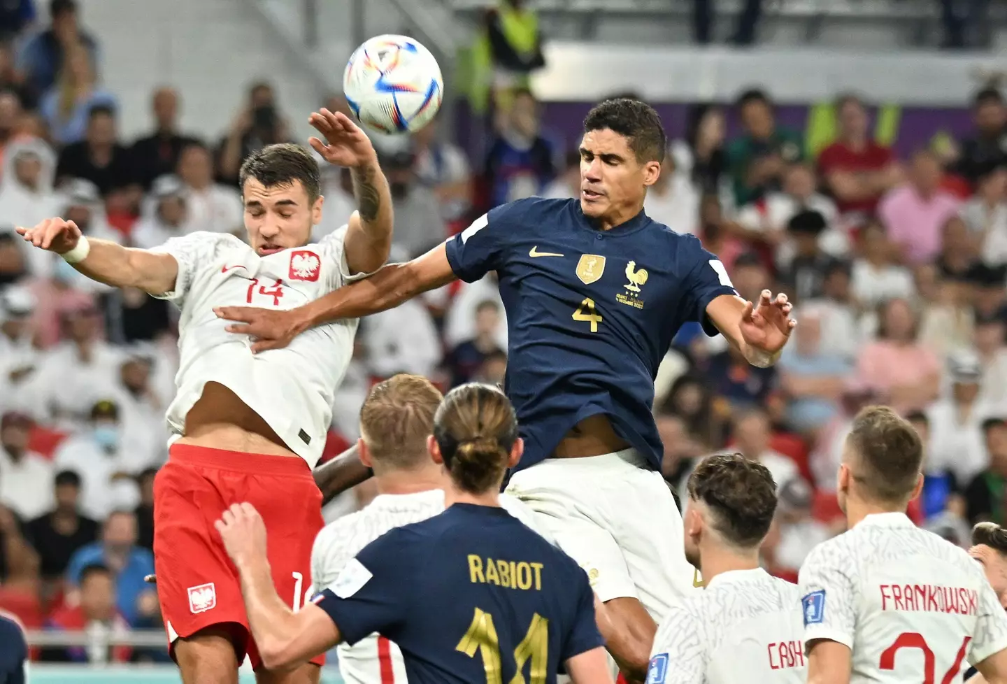 Varane battles with Jakub Kiwior of Poland. (Image
