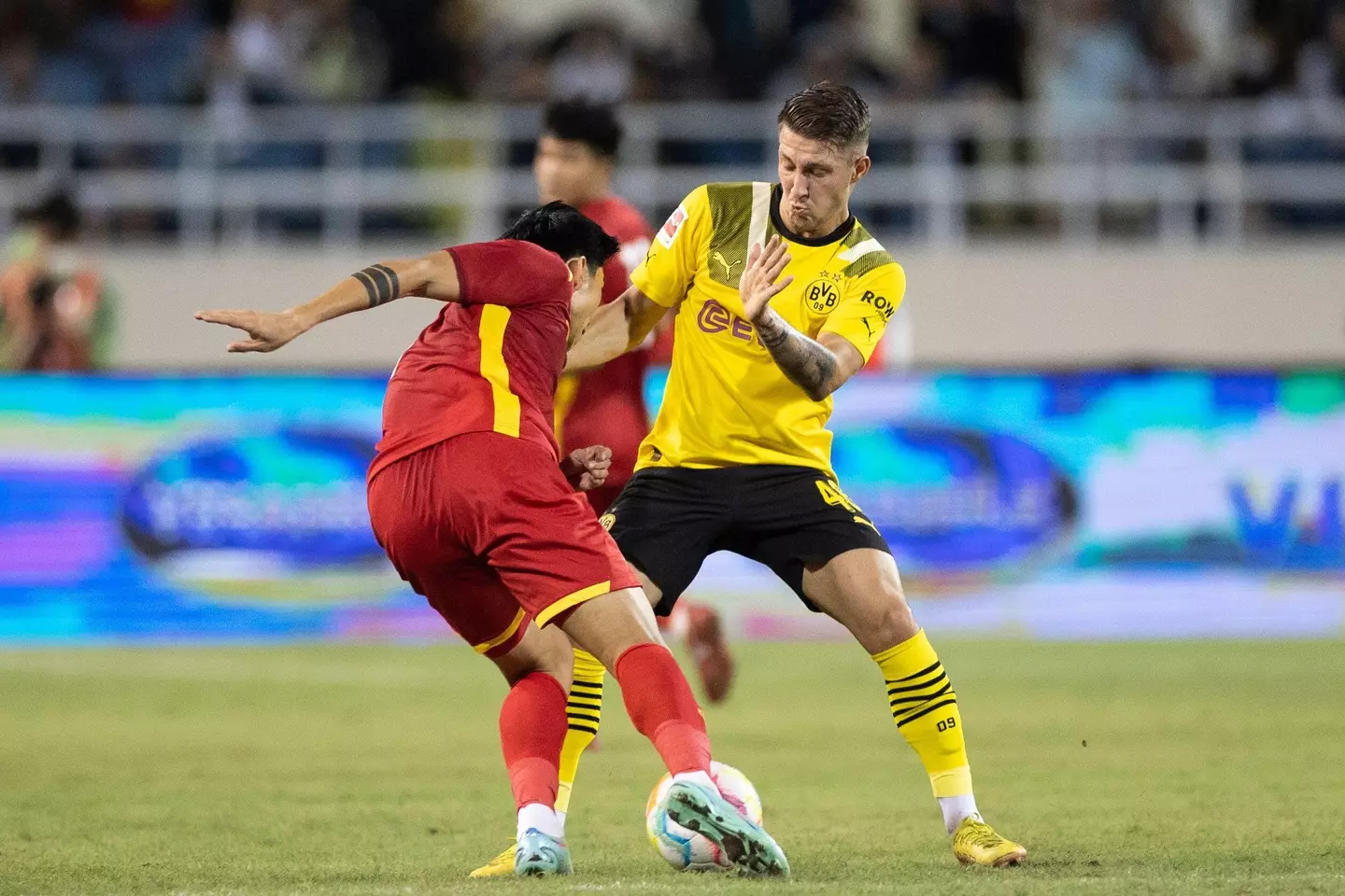 Borussia Dortmund's Marco Pasalic and Vietnam's Doan Van Hau fight for the ball. Image credit: Alamy
