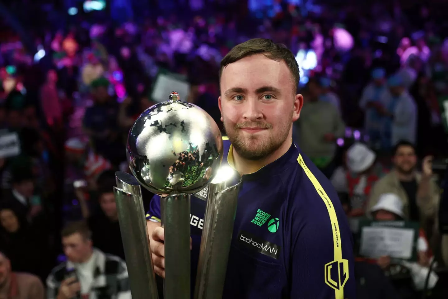 Luke Littler lifts the Sid Waddell Trophy after winning the 2025 World Darts Championship (Image: Getty)