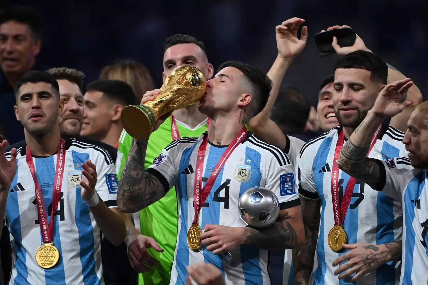 Enzo Fernandez plants a kiss on the World Cup. Image: Alamy