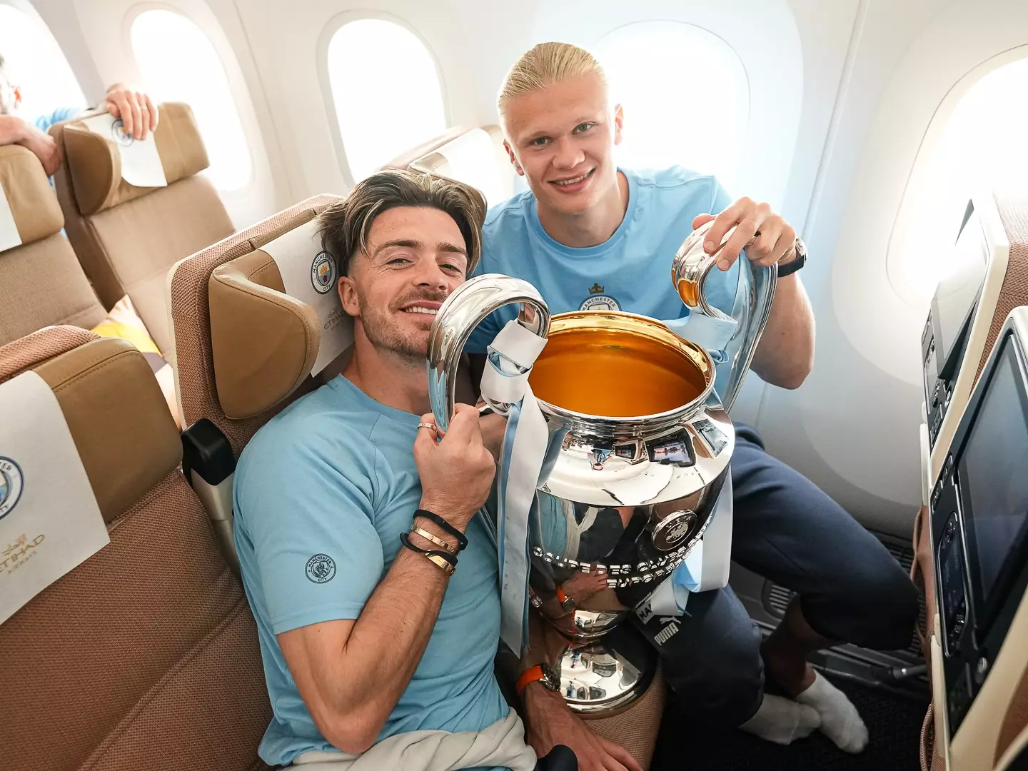 Erling Haaland and Jack Grealish pose for a picture with the Champions League trophy. Image: Getty