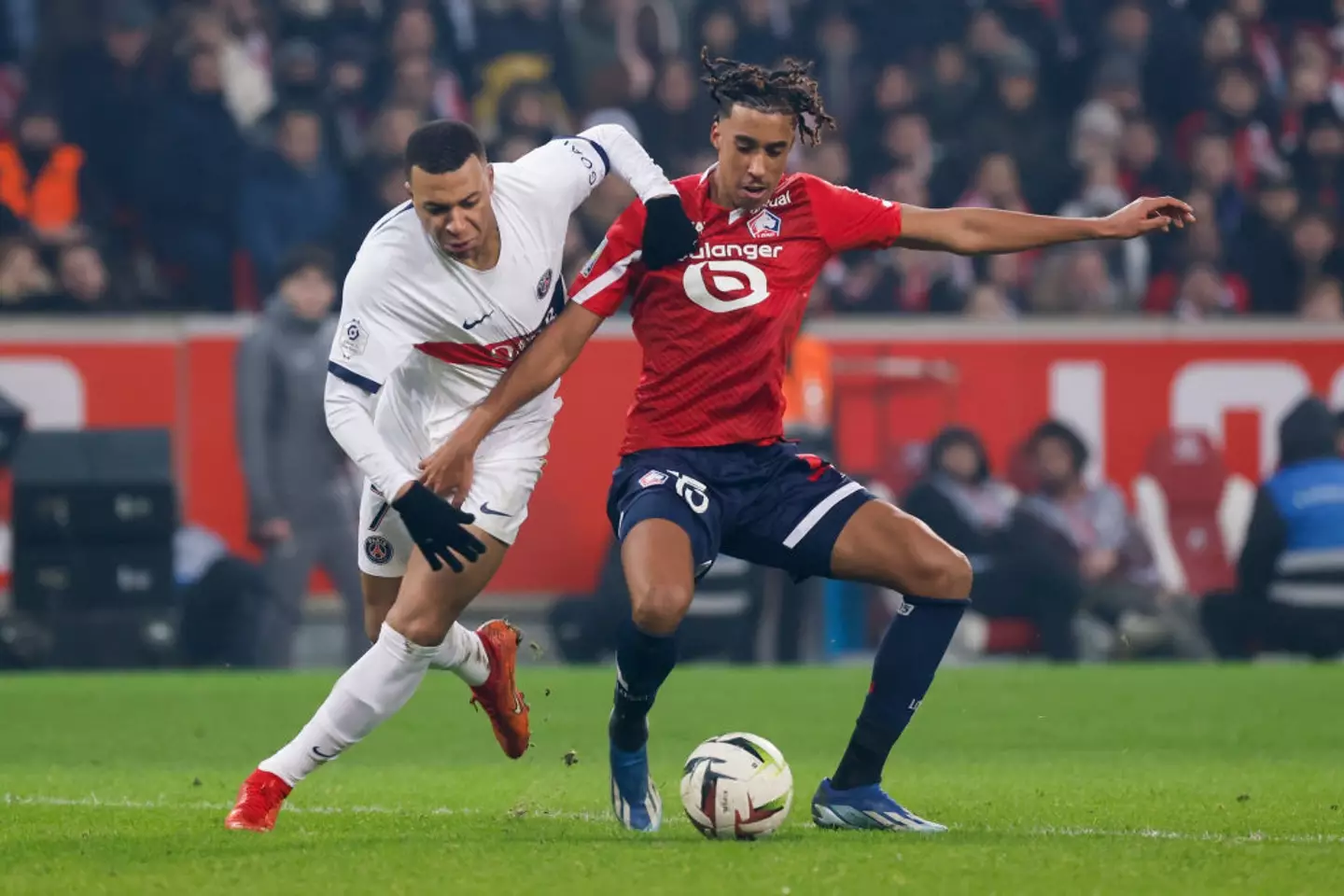 Lille's Leny Yoro battles for the ball with PSG's Kylian Mbappe (