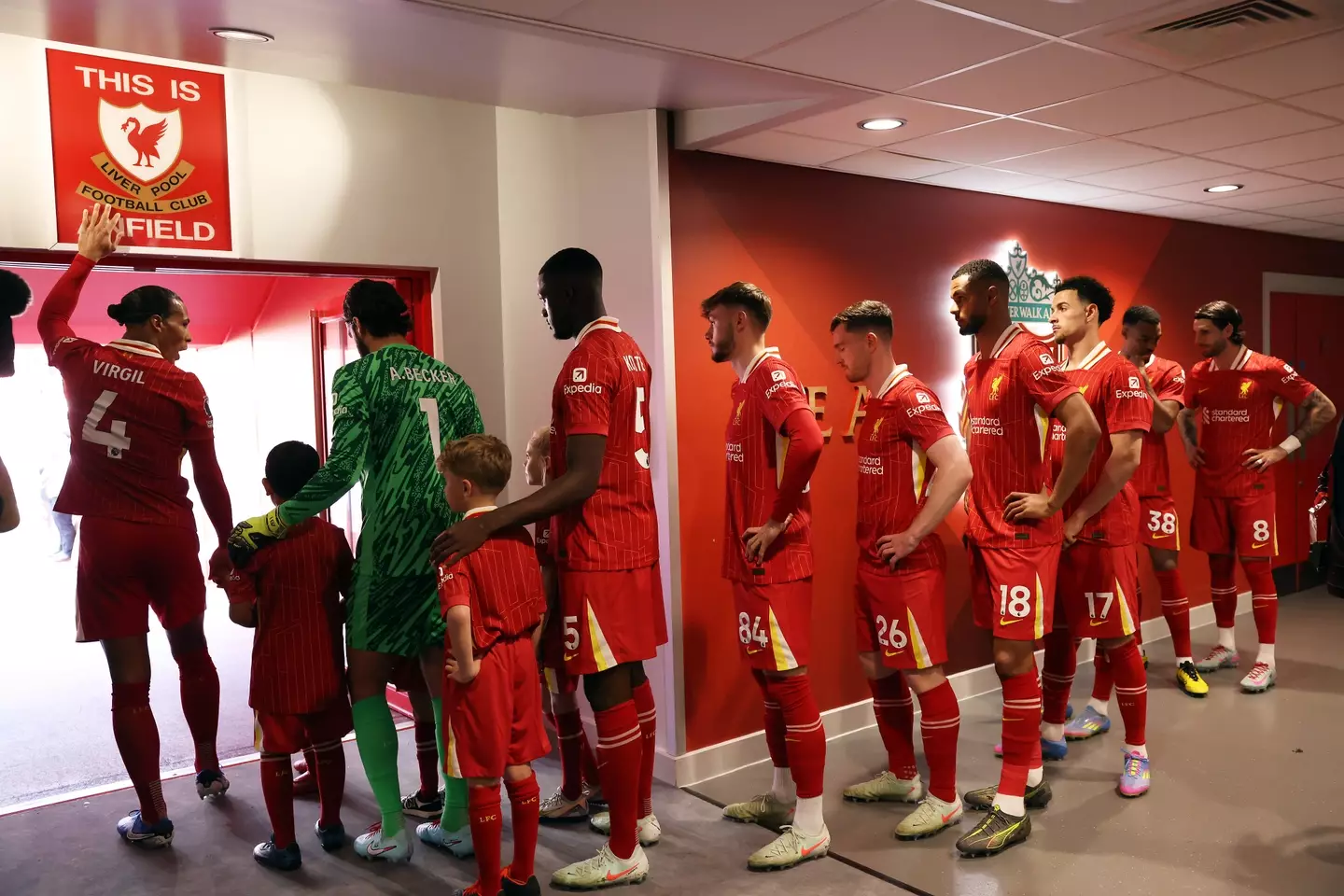 Virgil van Dijk touches the 'This Is Anfield' sign ahead of walking his team out. Image: Getty
