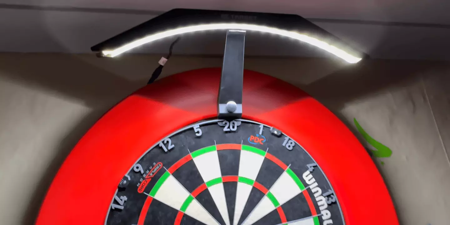 Darts lights are readily available to buy and attach to the board (Image: YouTube/Kevin Harnell Productions)