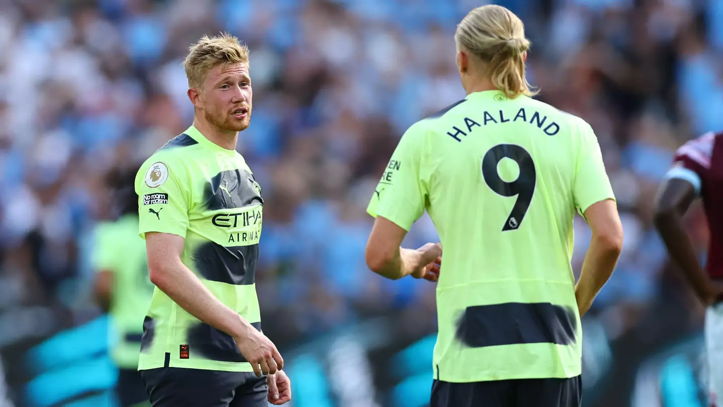 Kevin De Bruyne speaks with Erling Haaland on the pitch.