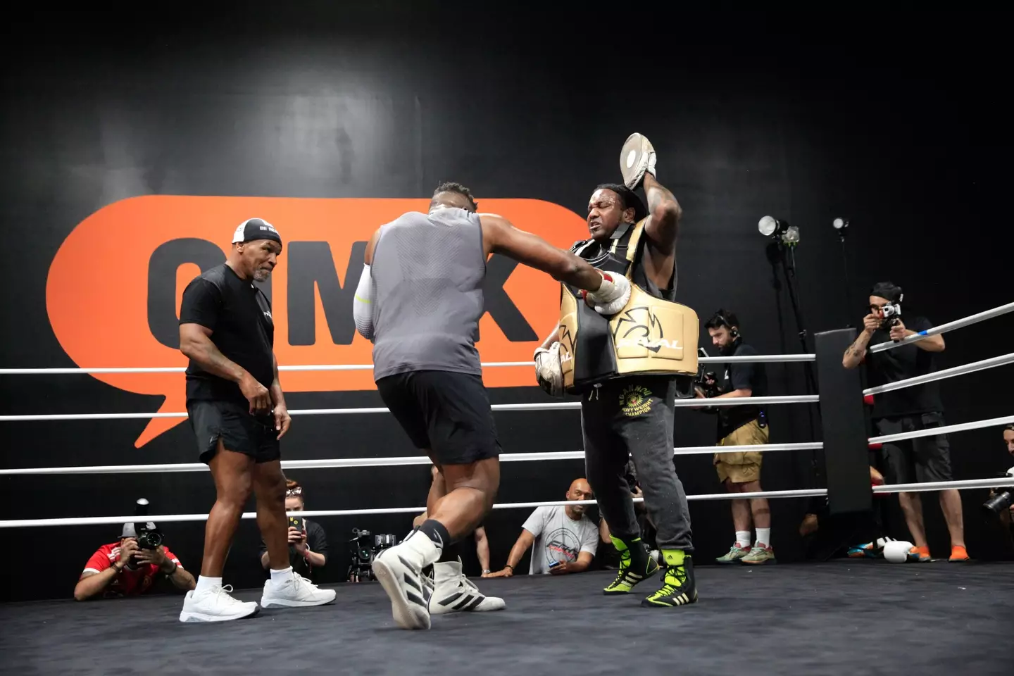 Francis Ngannou hitting the pads as Mike Tyson watches on. Image: Getty