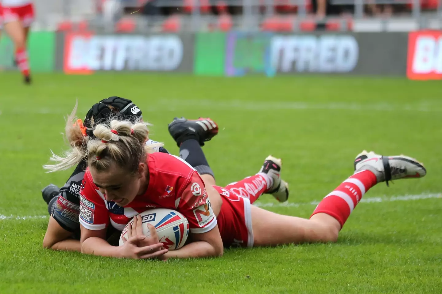 Travis Paige of St Helens scores a try against Castleford Tigers Women.