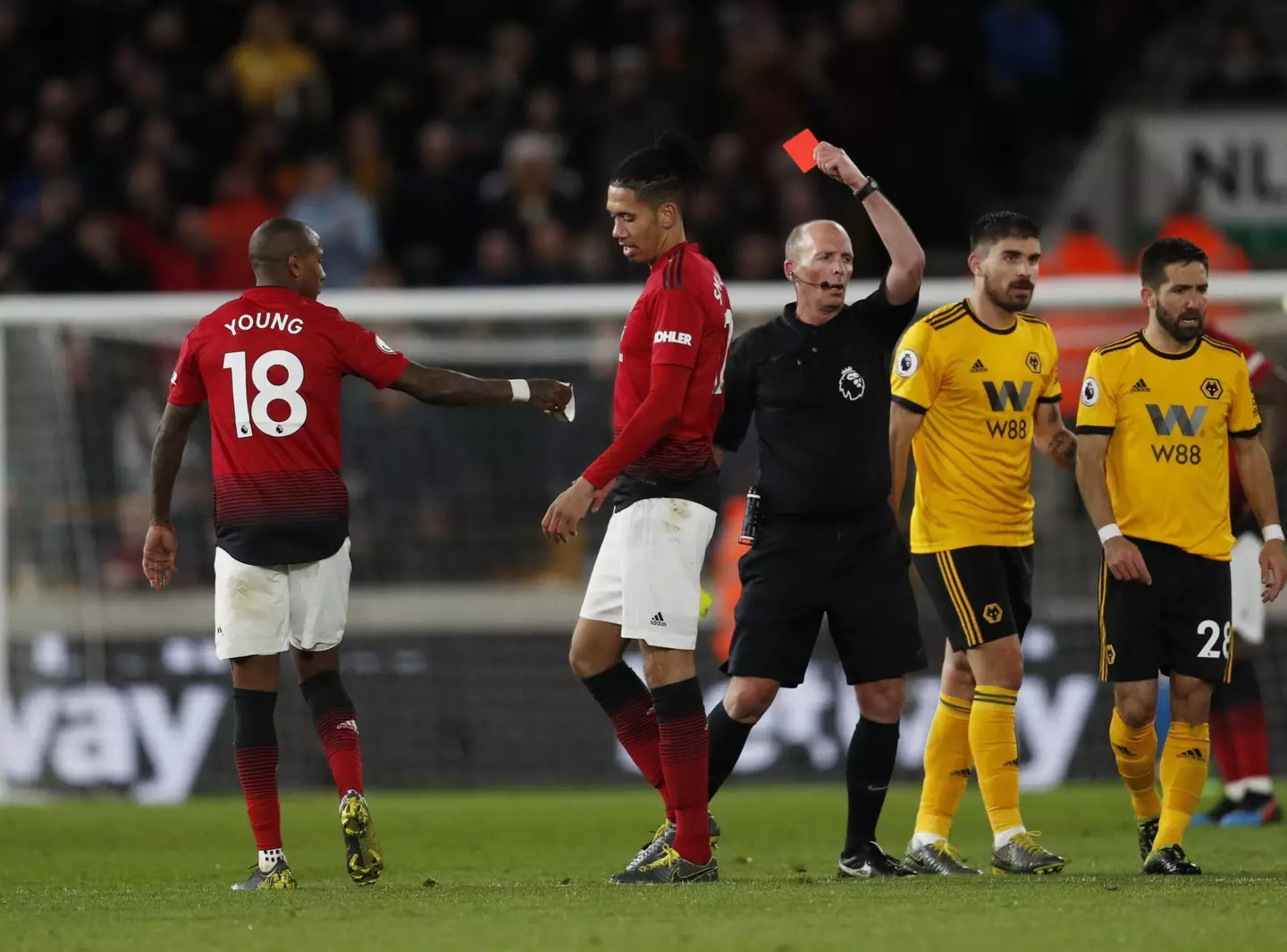 Dean brandishes his 100th Premier League red card. Image: PA Images