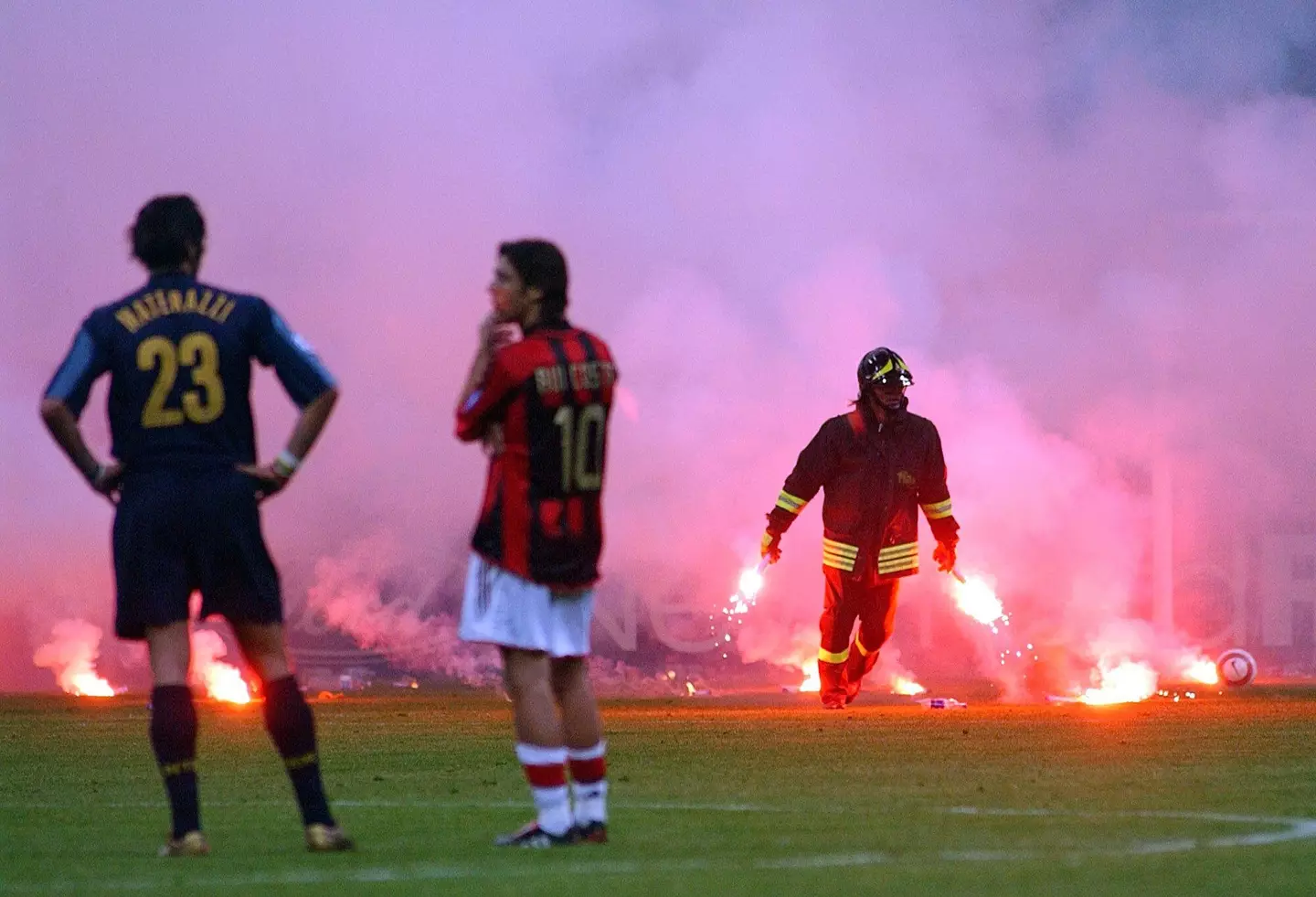 Materazzi and Costa talk as a fireman tries to put out the flares. Image: Alamy