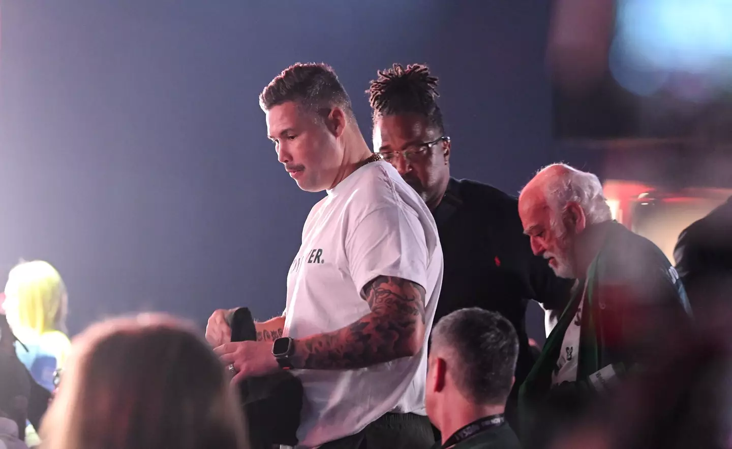 Tony Bellew gets escorted out of the press conference following his stunt. Image: Getty