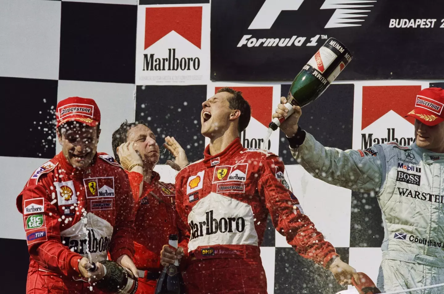 Michael Schumacher celebrates on the podium after winning a race. Image: Getty