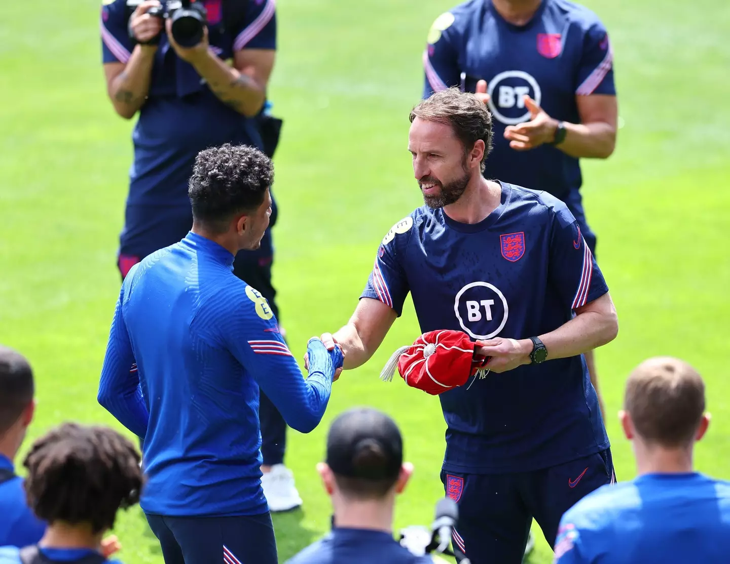 Gareth Southgate manager of England gives out a cap to James Justin during training at FC Bayern Campus, Munich. Image credit: Alamy