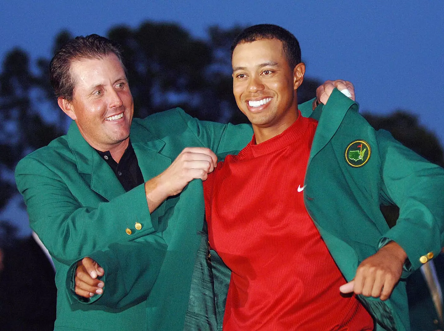 Tiger Woods receiving his green jacket from previous winner Phil Mickelson after the 2005 Masters (Image: Getty)