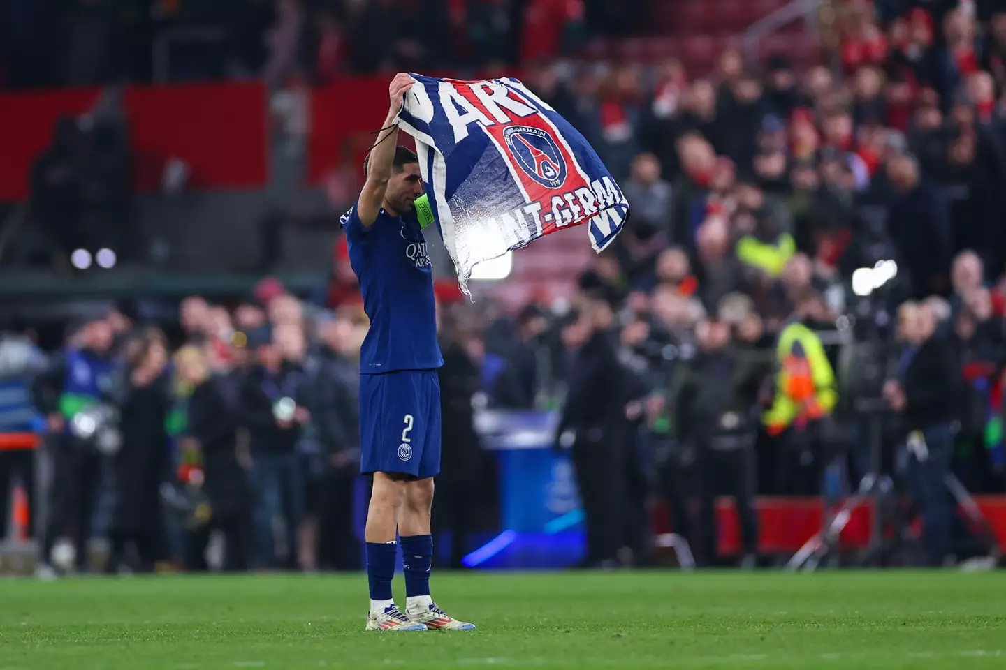 Achraf Hakimi taunts Liverpool fans by holding up a flag to the Kop end. Image: Getty