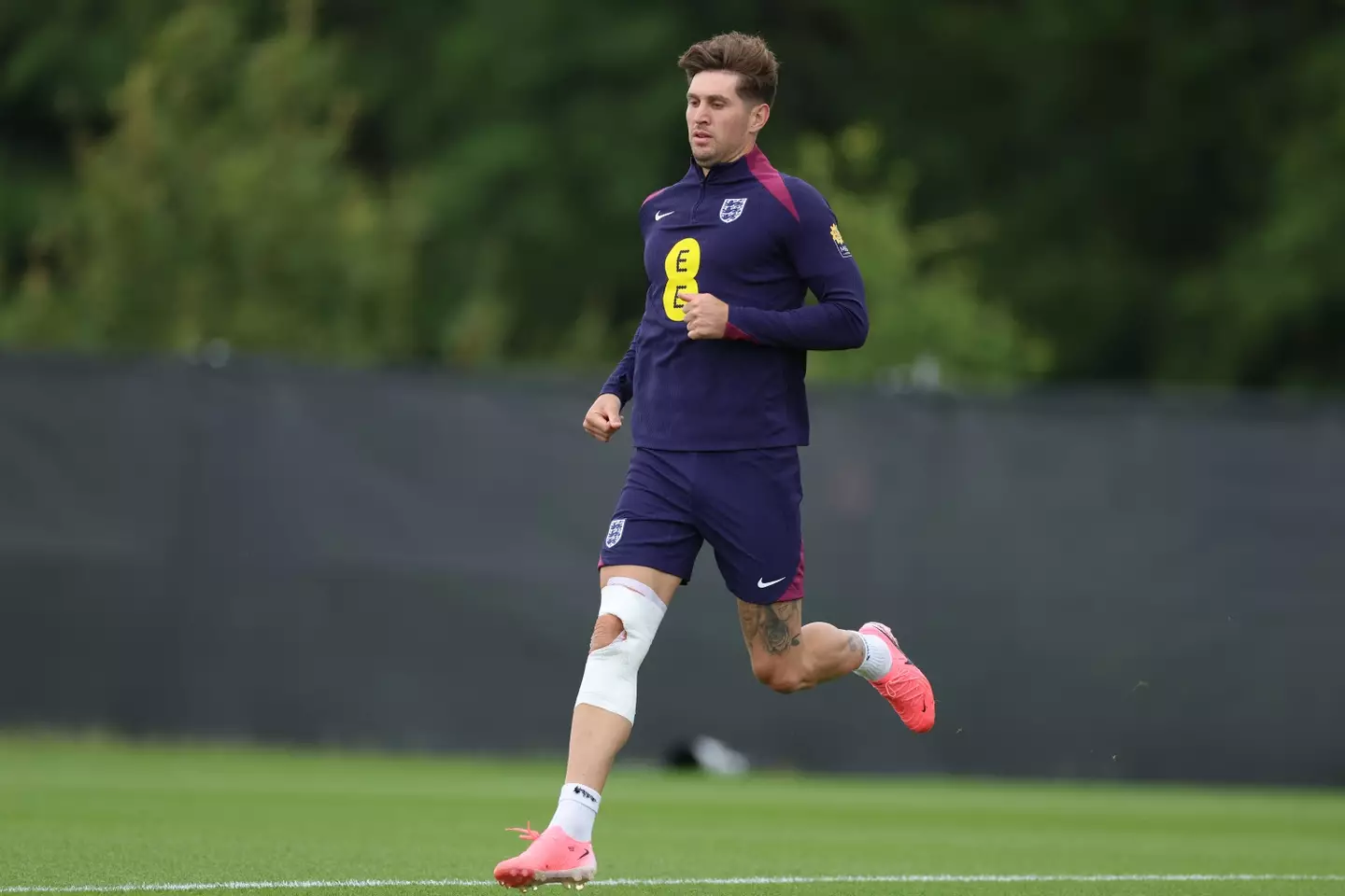 John Stones trains with heavy strapping on his right knee. Image: Getty