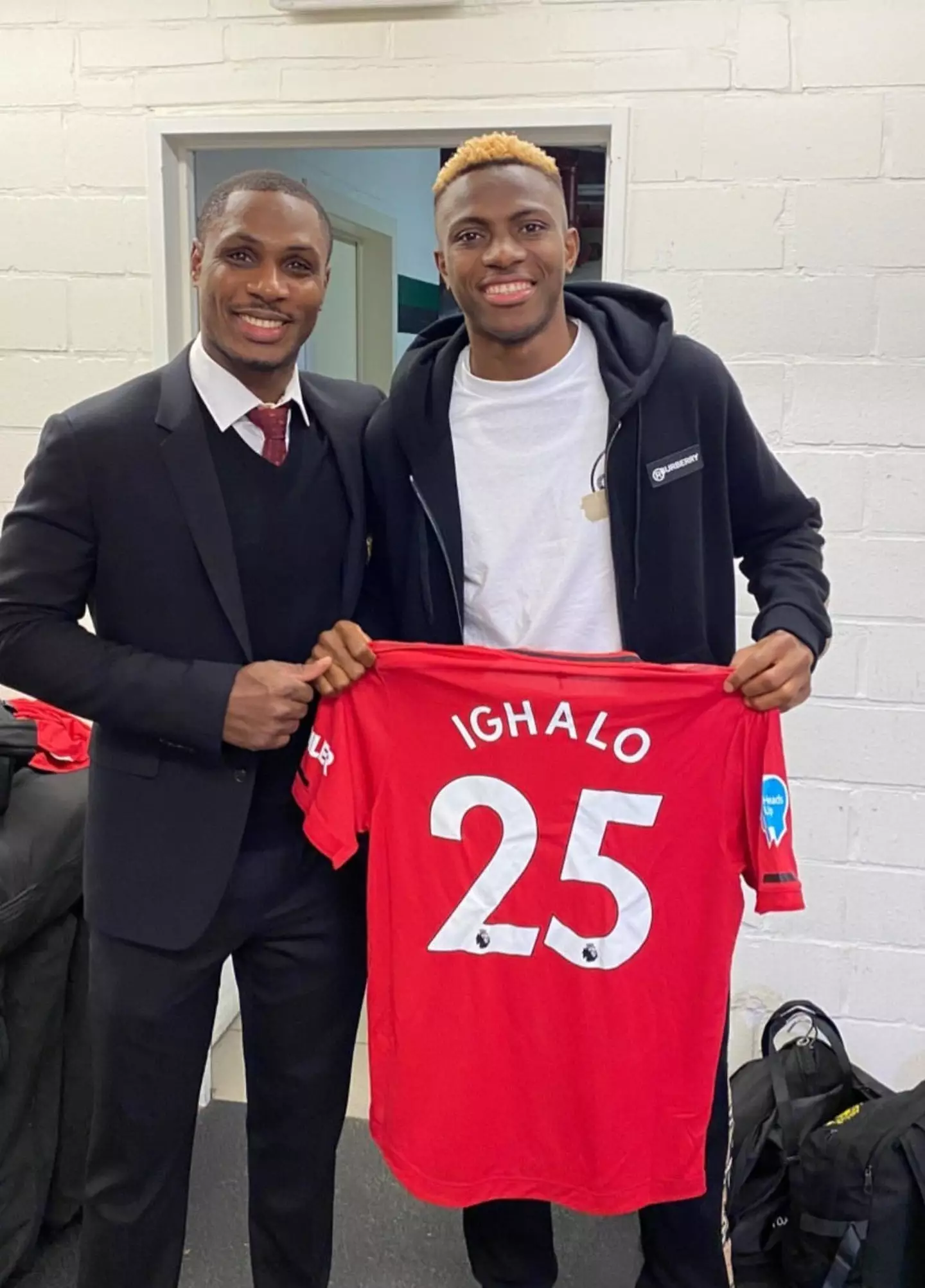 Victor Osimhen posing with Odion Ighalo, holding the latter's Manchester United match shirt.