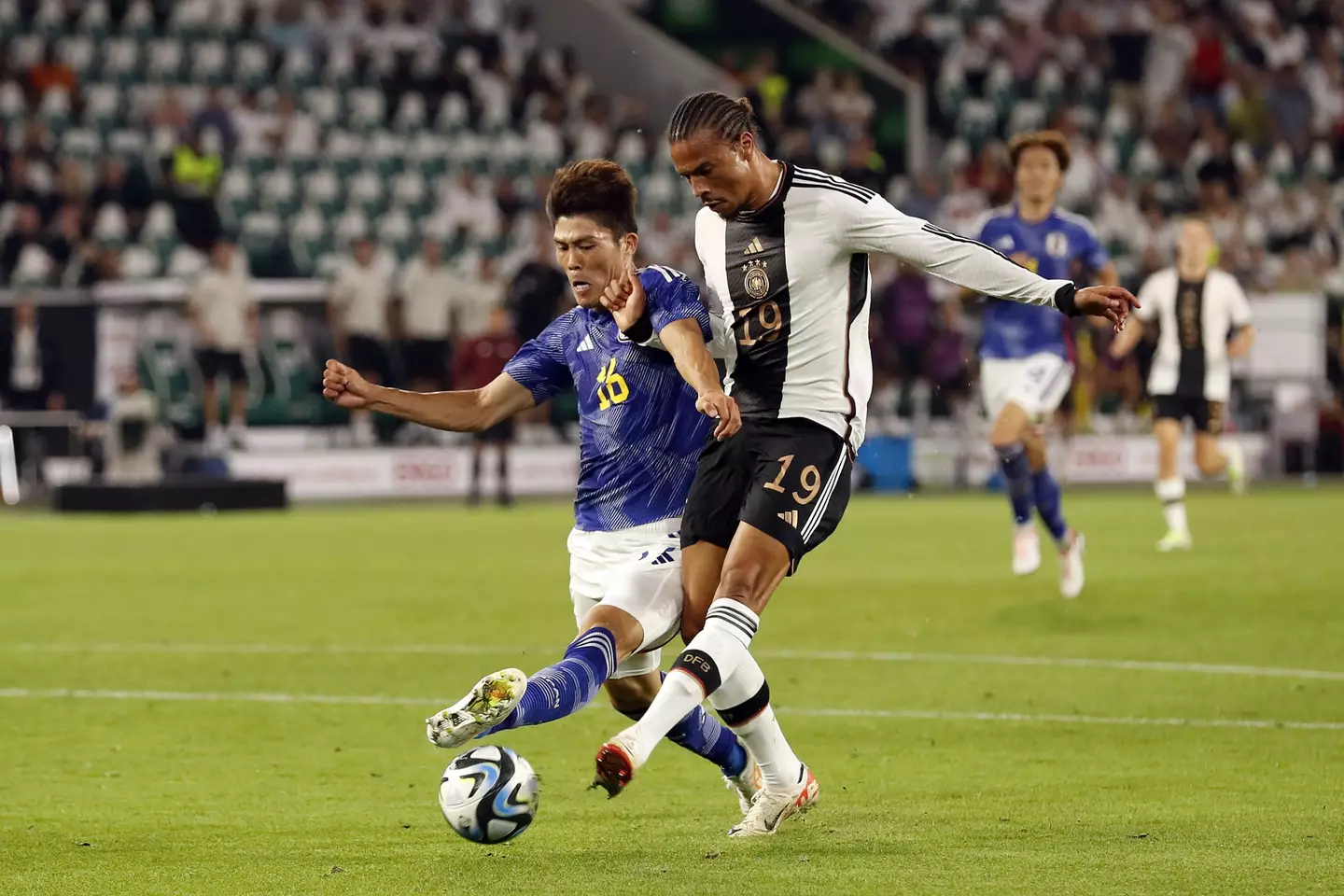 Takehiro Tomiyasu takes on Leroy Sane. (