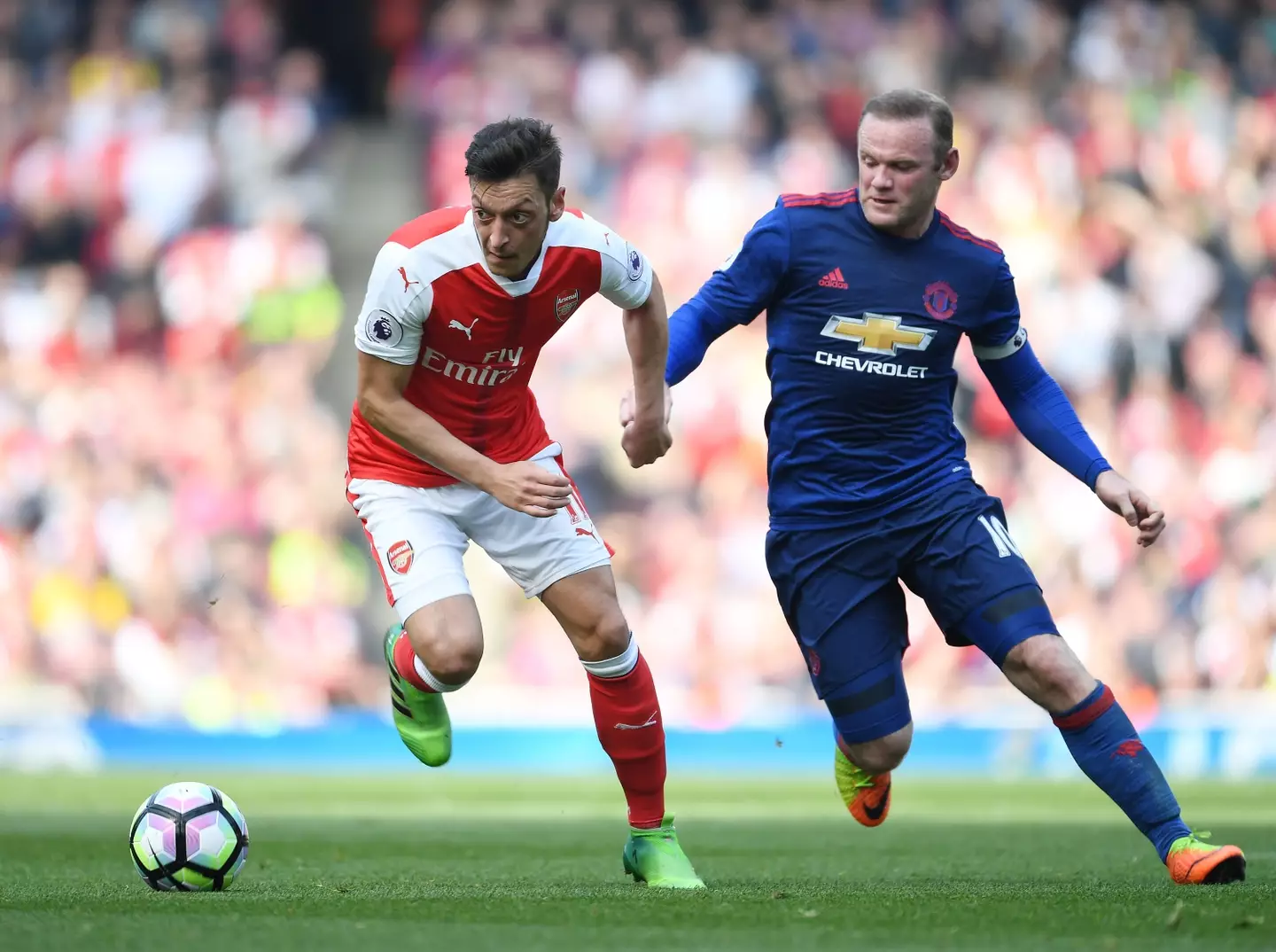 Mesut Ozil and Wayne Rooney during a fixture between Arsenal and Manchester United. Image: Getty