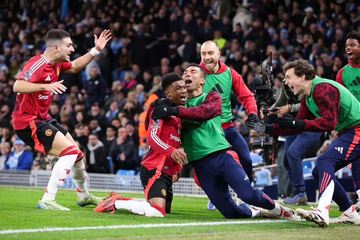 Amad celebrates with his Man Utd teammates after scoring in stoppage time. Image credit: Getty