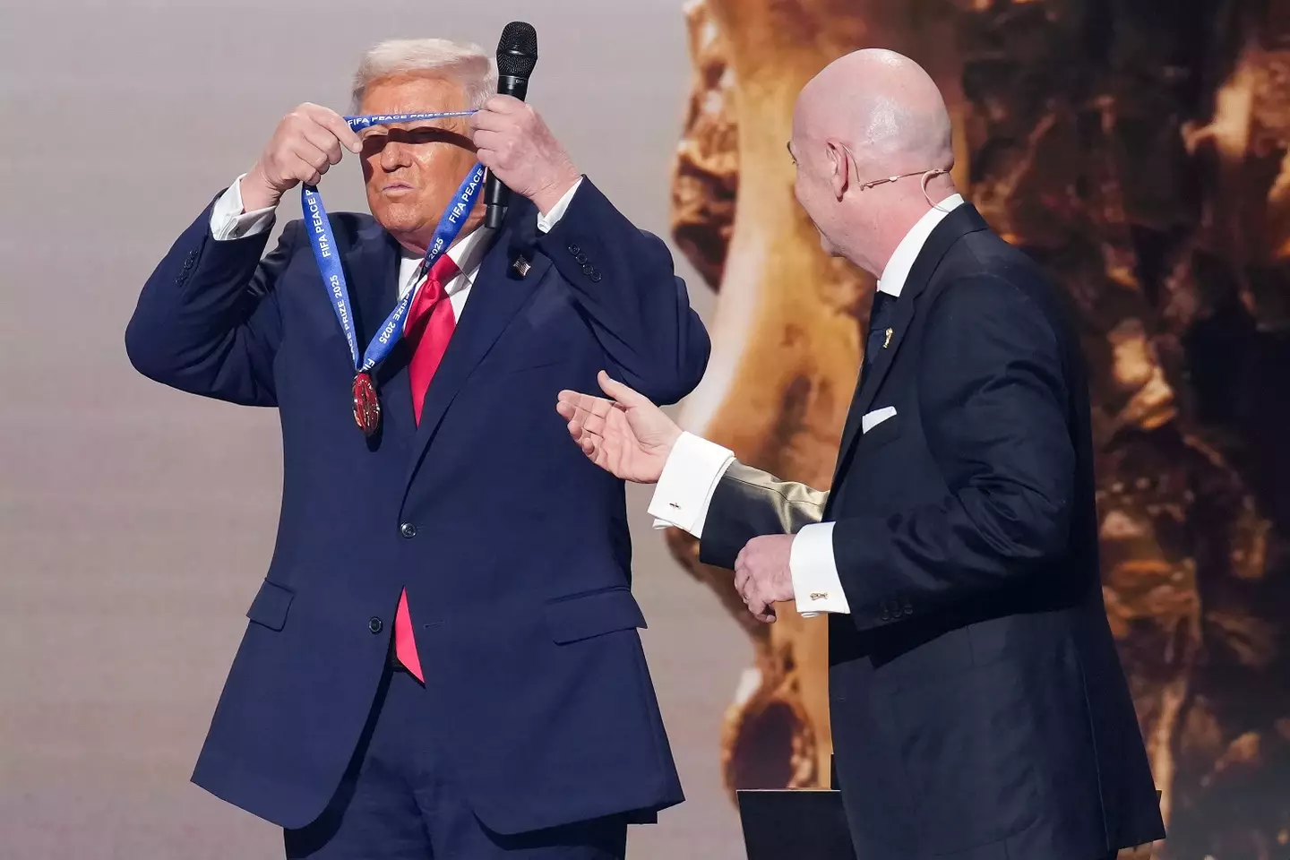 Trump places the FIFA Peace Prize around his neck. Image credit: Getty