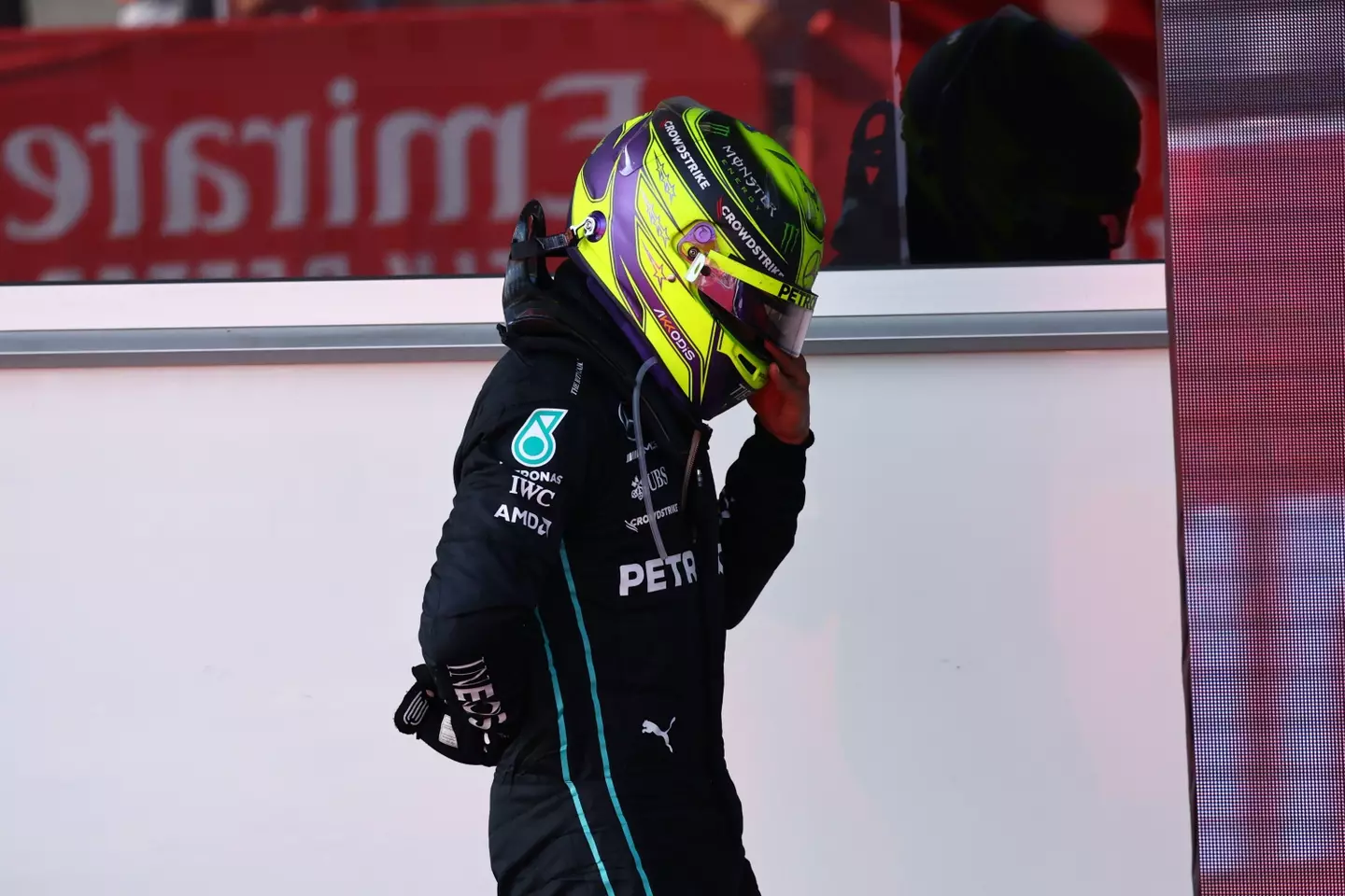 Hamilton holding his back after getting out of the car. Image: Alamy