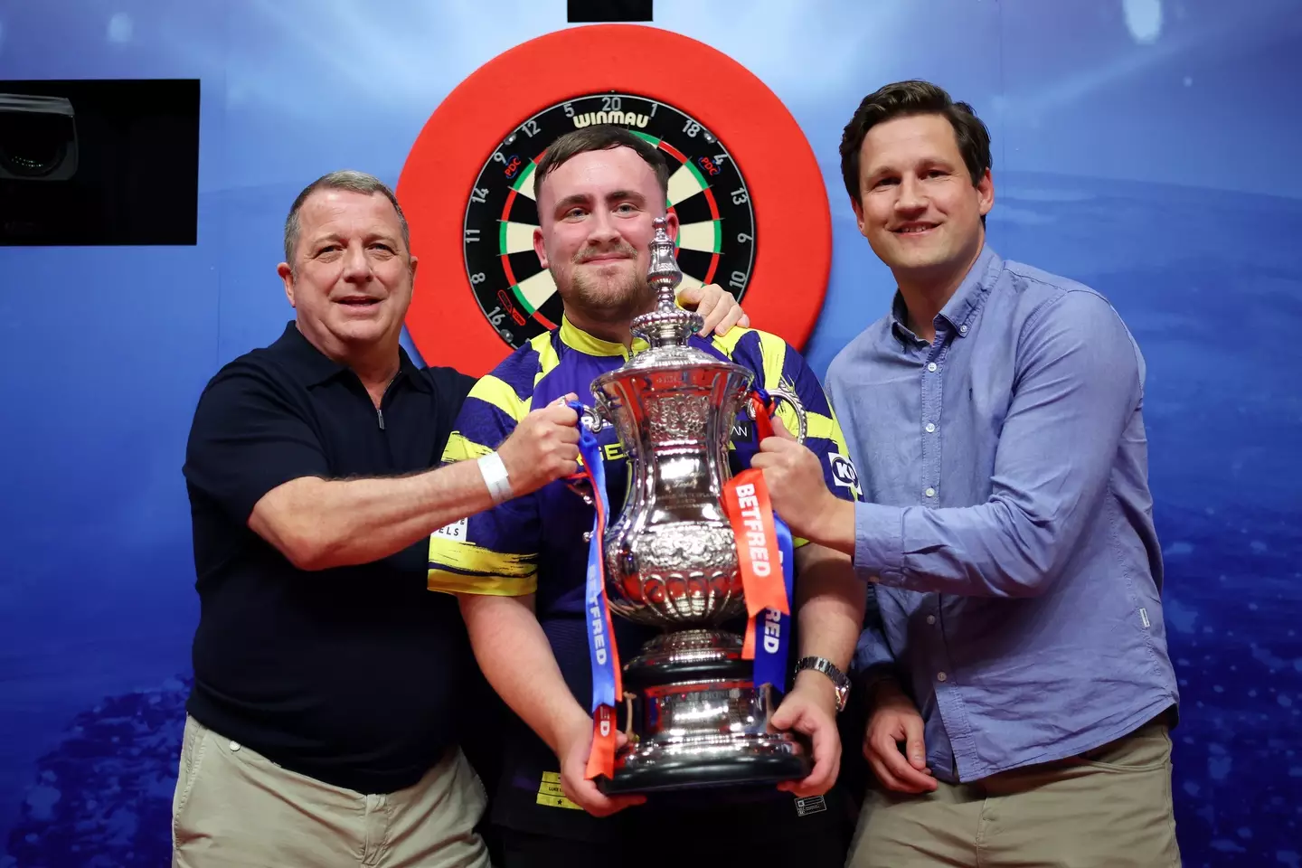 Luke Littler pictured alongside Garry Plummer, Owner of Target Darts, and James Tattersall, Managing Director of Target Darts. Image credit: Getty