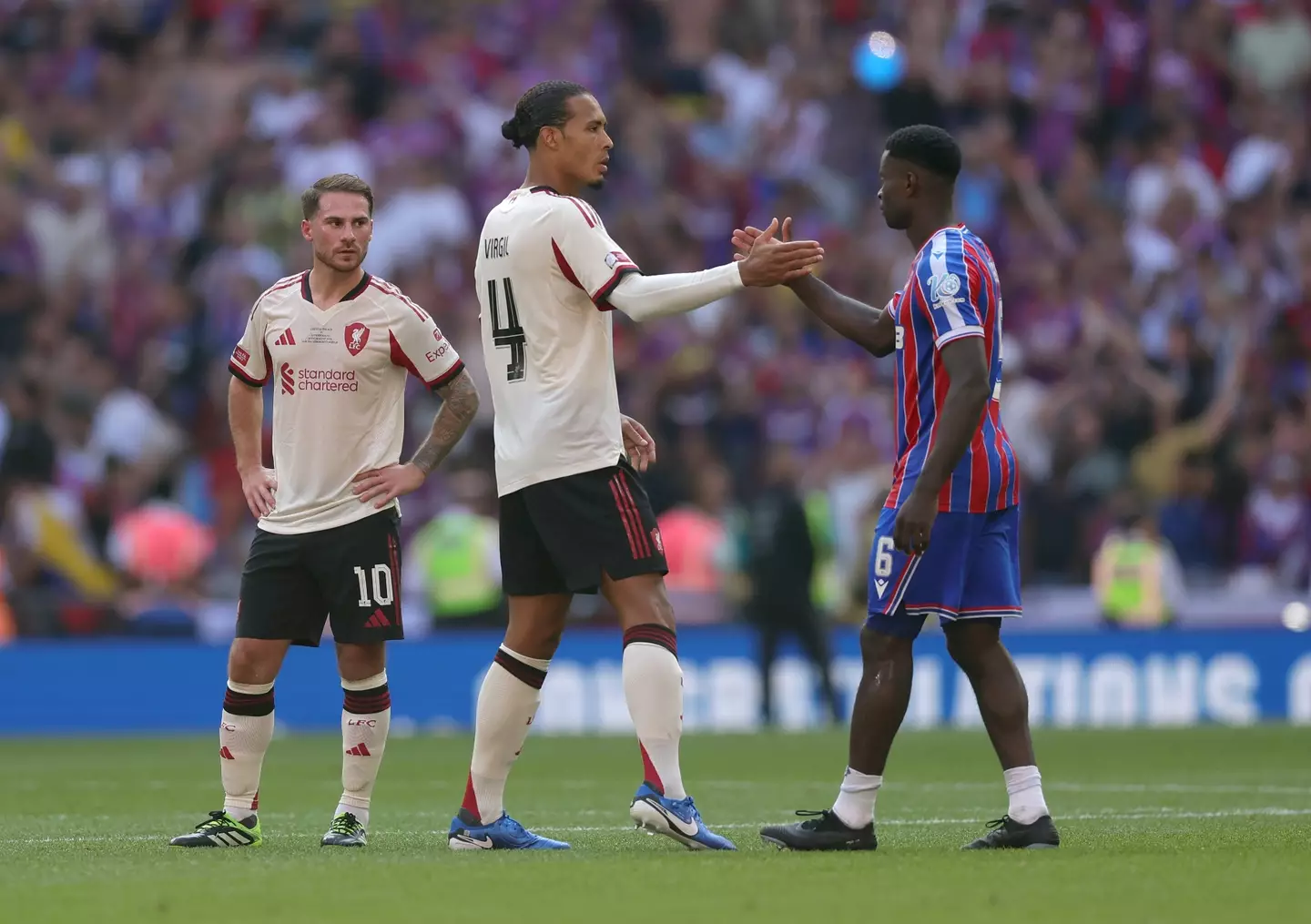 Marc Guehi shakes hands with Liverpool captain Virgil van Dijk. Image: Getty