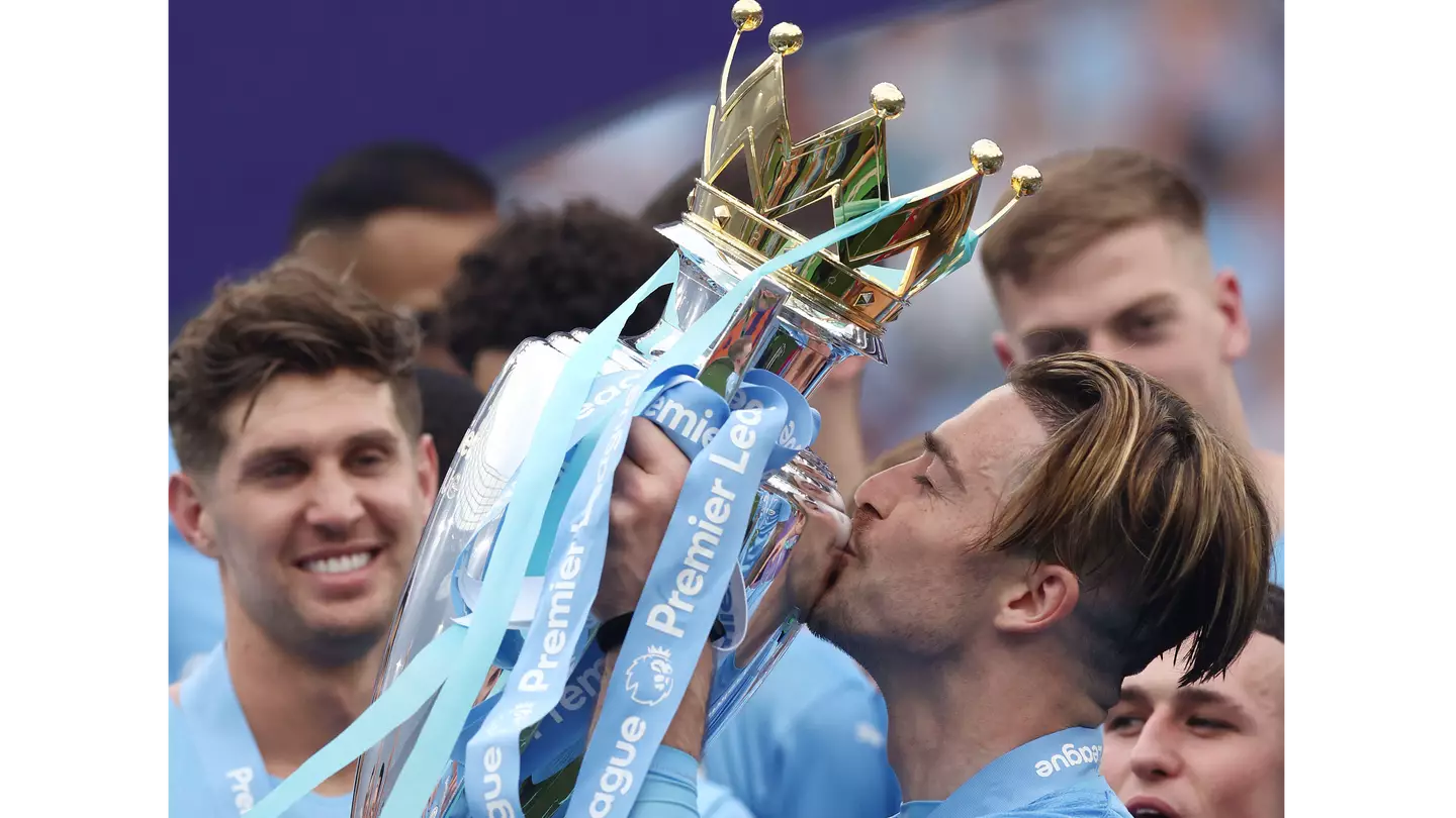 Jack Grealish celebrates winning the Premier League trophy with Manchester City (Alamy)