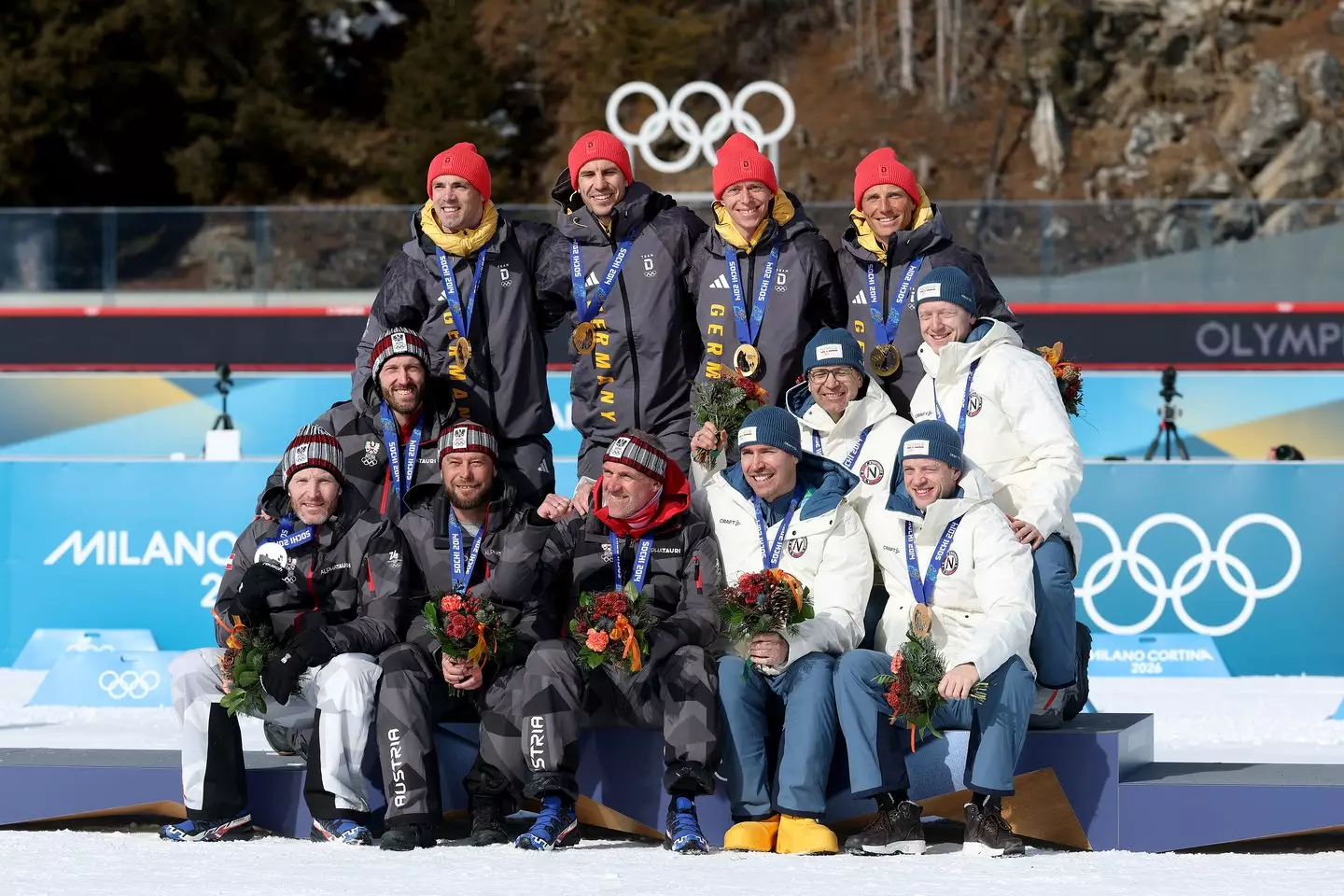 Gold medalists Erik Lesser, Daniel Boehm, Arnd Peiffer and Simon Schempp of Team Germany, Silver medalists Christoph Sumann, Daniel Mesotitsch, Simon Eder and Dominik Landertinger of Team Austria and Bronze medalists Tarjei Boe, Johannes Thingnes Boe, Ole Einar Bjoerndalen and Emil Hegle Svendsen of Team Norway pose for a photo during the reallocation ceremony for Sochi 2014 Olympic Winter Games. Image credit: Getty