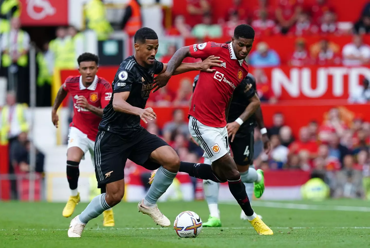 William Saliba tussles with Marcus Rashford.