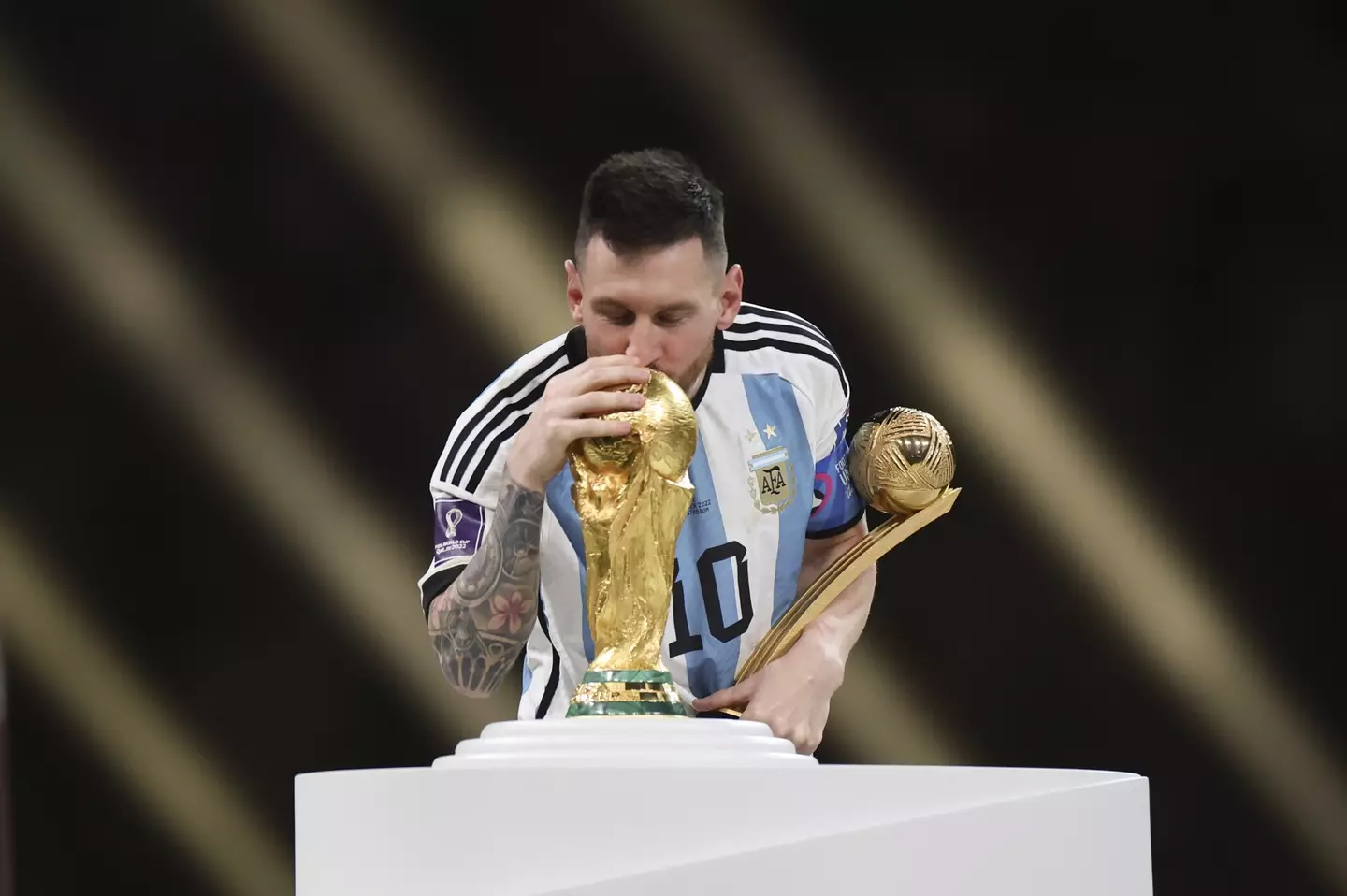 Lionel Messi kissing the World Cup trophy