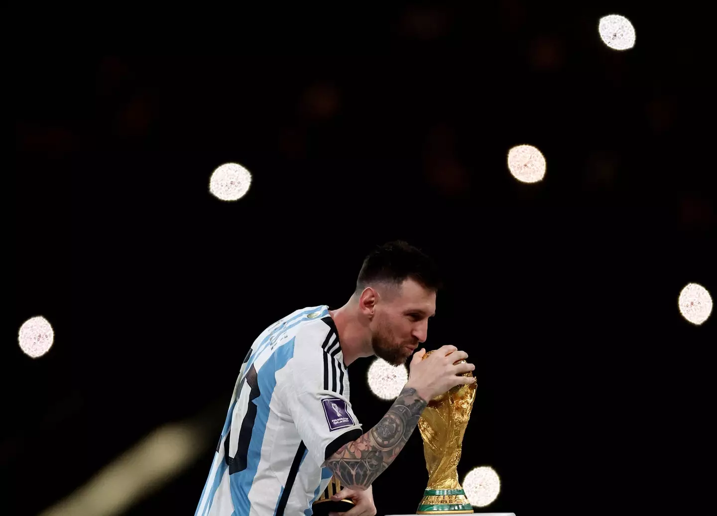 Lionel Messi plants a kiss on the World Cup. Image: Alamy 
