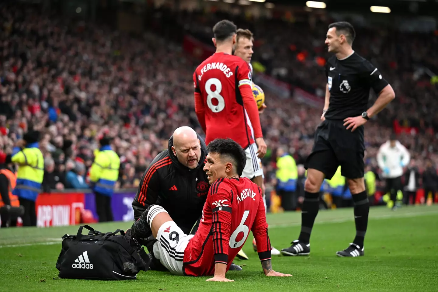 Lisandro Martinez receives treatment after picking up an injury. Image: Getty