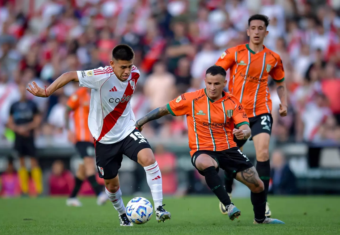 Claudio Echeverri drives the ball against Cristian Nuñez of Banfield. Image credit: Getty