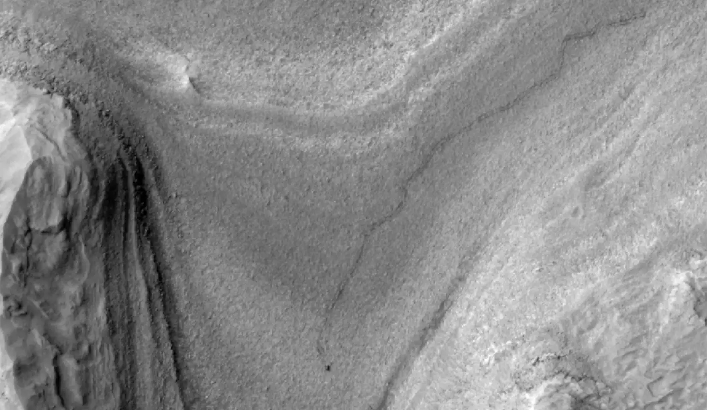 NASA’s Curiosity rover appears as a dark speck in this contrast-enhanced view of Mars. (NASA / JPL-Caltech/ University of Arizona)