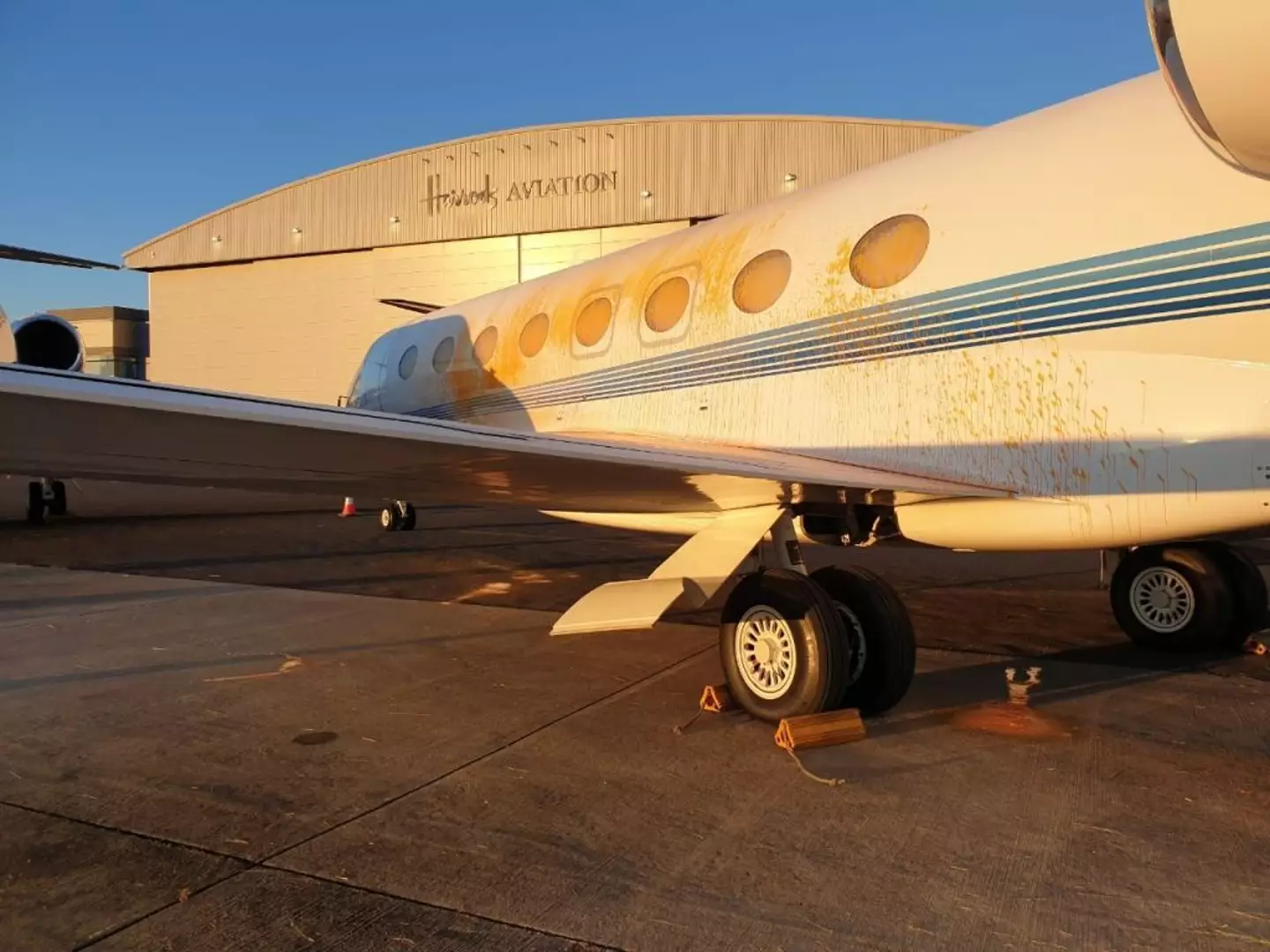 Just Stop Oil activists broke into Stansted Airport and spray painted several jets in the group's recognizable orange (Just Stop Oil / Handout/Anadolu via Getty Images)
