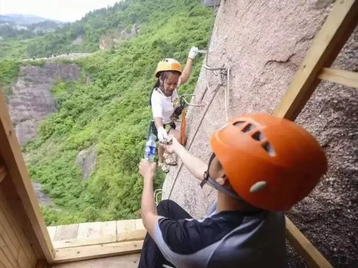 A climber being handed a bottle of water from the Shiniuzhai National Geological Park convenience store (Business Insider/Weibo)
