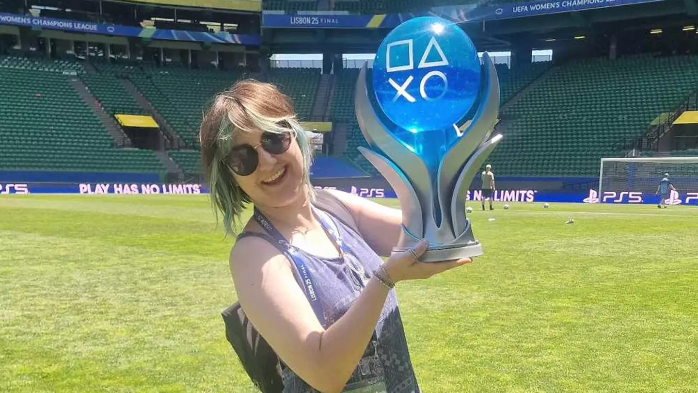 Sara holding the official PlayStation platinum trophy