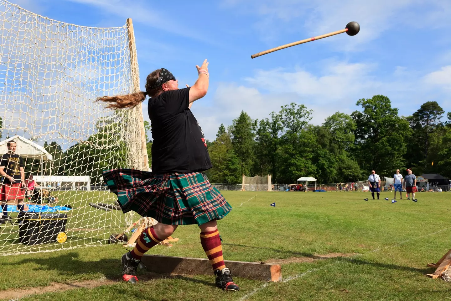 Competitor at Scottish highland games throwing the 22 pound hammer, a traditional Scottish competition.