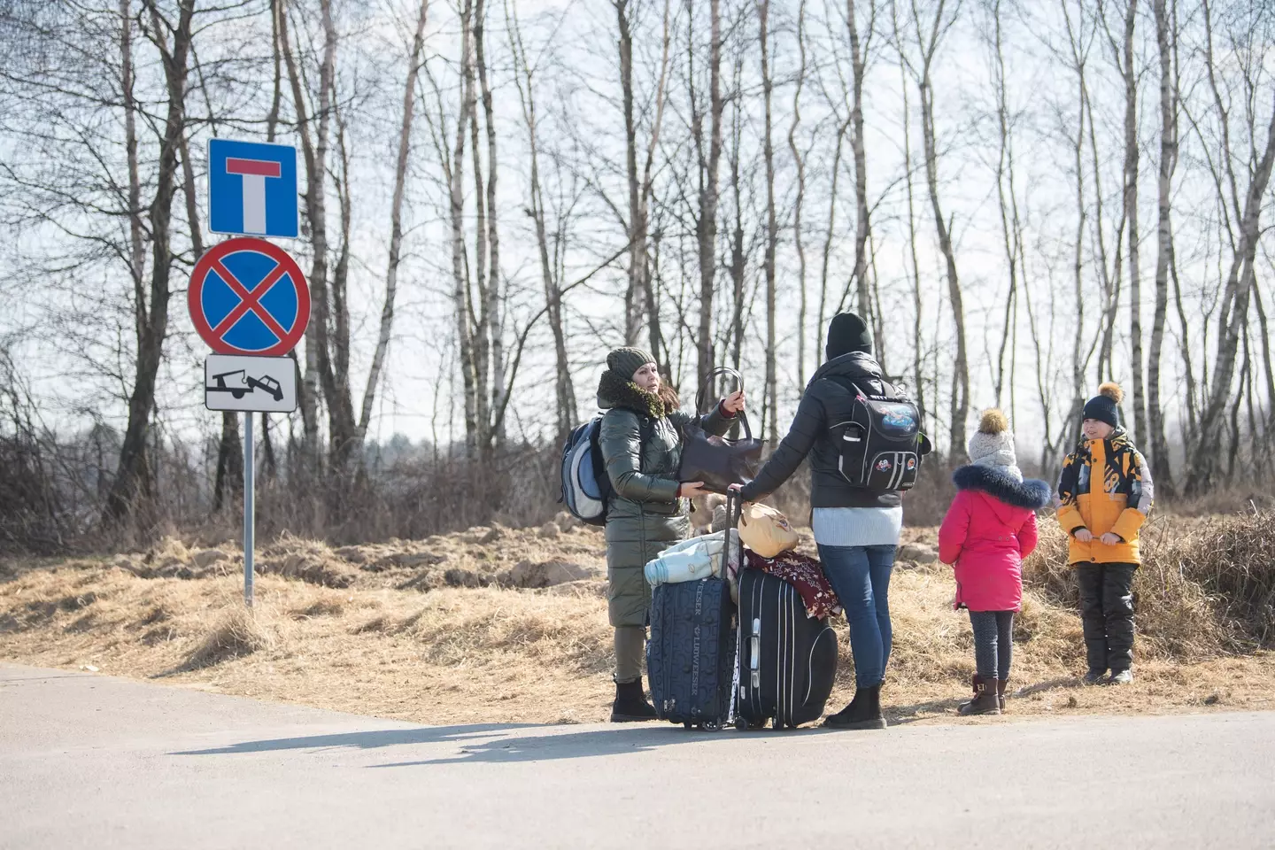 Oxana (l) and Maria, as well as their children, are fleeing from the village of Shklo near Yavoriv, stand at the Budomierz border crossing between Ukraine and Poland.