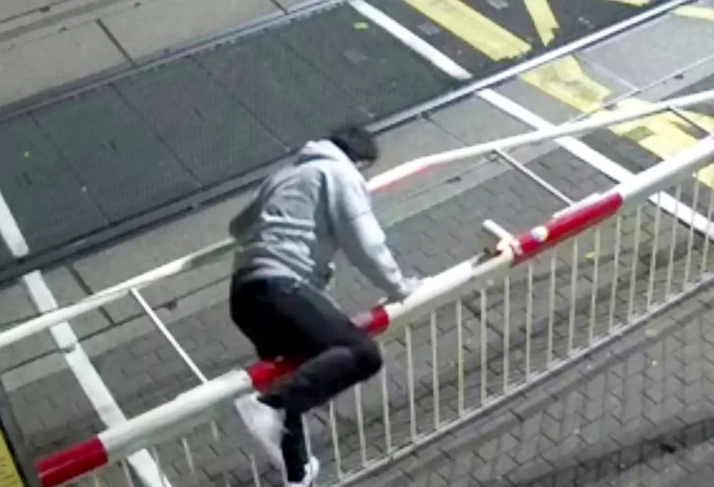 CCTV caught the young man clambering over the barrier and walking across the tracks.