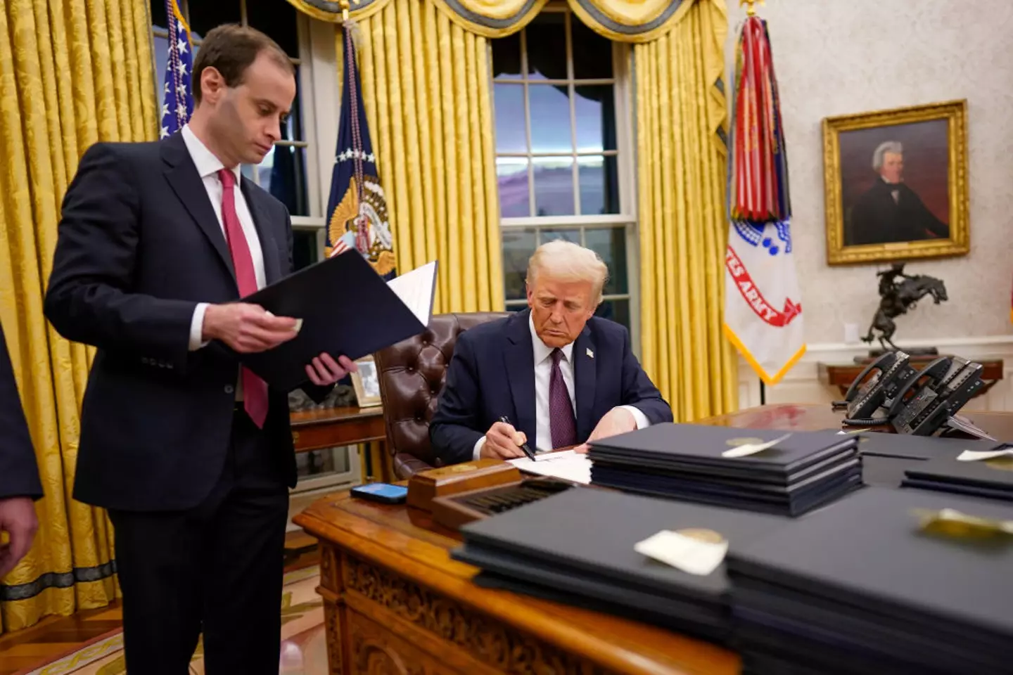 Family photos, different portraits and military flags can be seen in Donald Trump's Oval Office (Jabin Botsford /The Washington Post via Getty Images)
