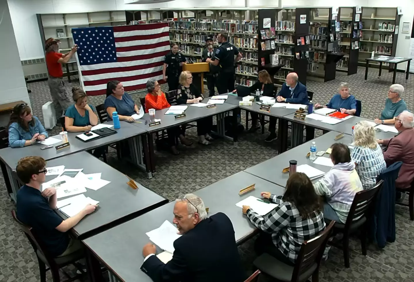 Tim Bodnar, the man in the red t-shirt standing up, caused the meeting to be paused multiple times (YouTube/Regional School Unit 67)